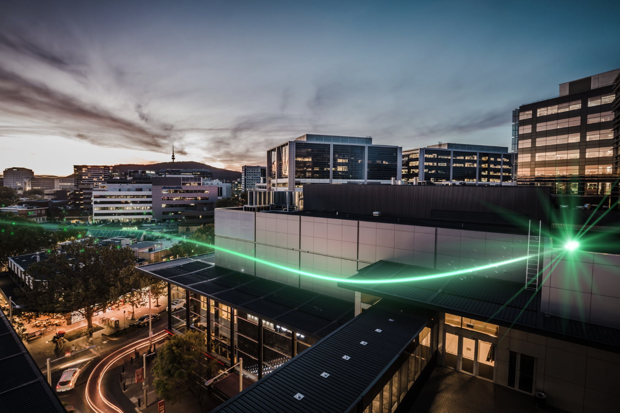 Green spark flying over Canberra city street and buildings 